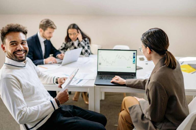 Business team analyzing growth data on laptop in office meeting