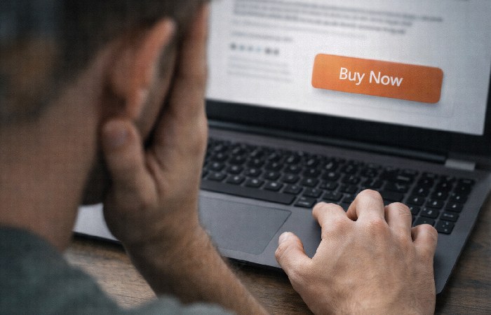 Person hesitating before purchasing from an unknown website